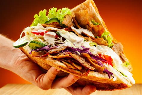  Döner Kebab: Un trionfo di sapori speziati e fragranti avvolti in un morbido abbraccio di pane pita!